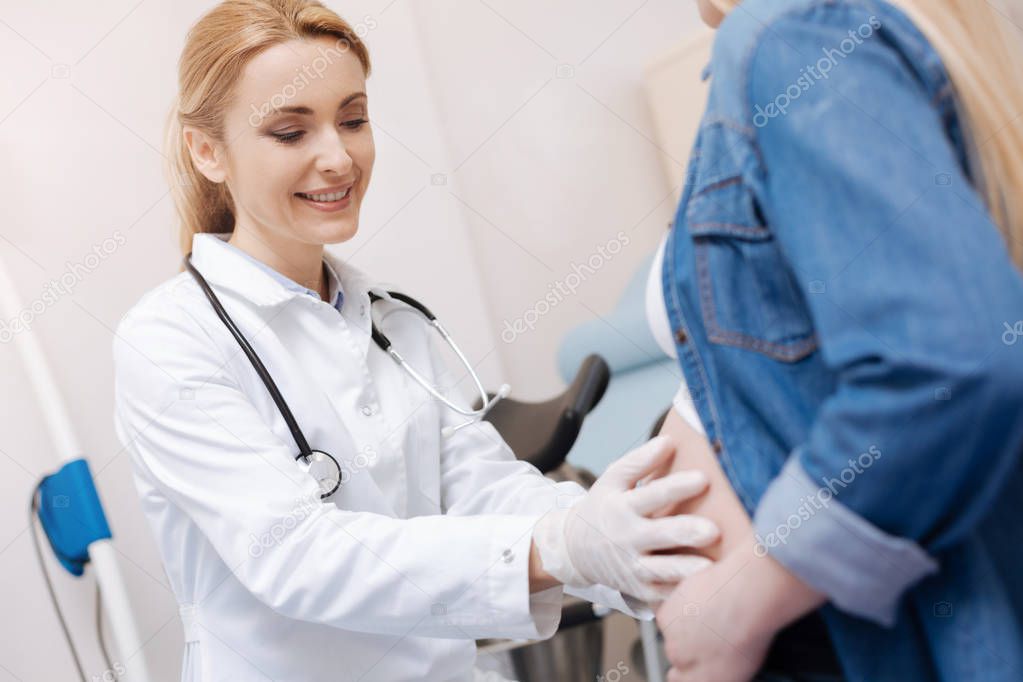 obstetrician examining pregnant belly