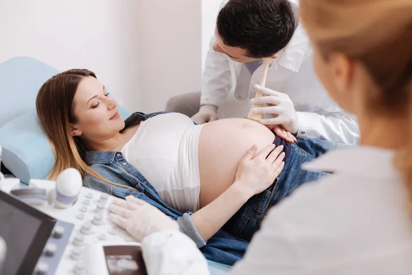 Artsen die bieden: onderzoek van de zwangere buik — Stockfoto