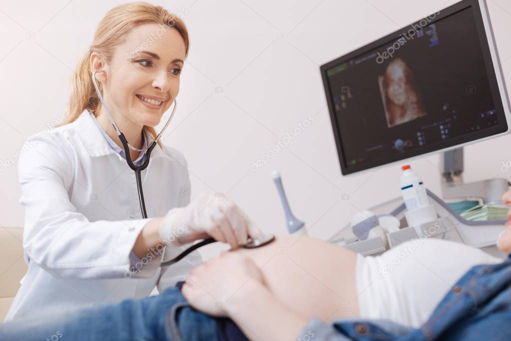 gynecologist examining fetus heart beating