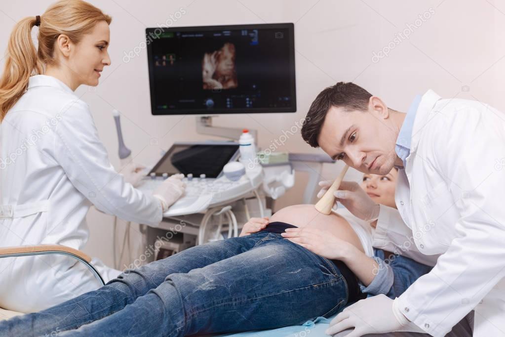 practitioners providing pregnant belly checkup 