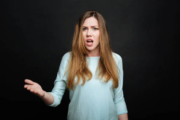 Эмоциональная молодая женщина демонстрирует недовольство в студии — стоковое фото