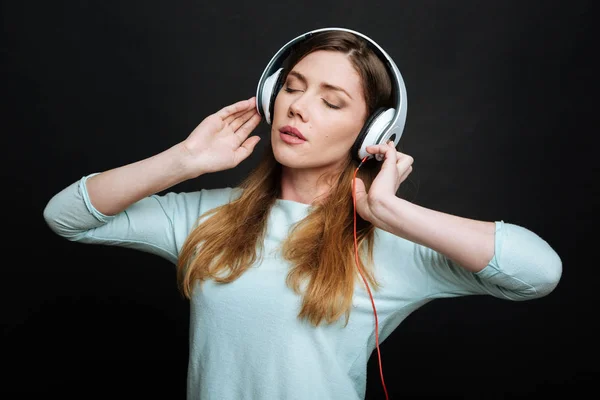 Jovem satisfeita desfrutando de música no estúdio — Fotografia de Stock