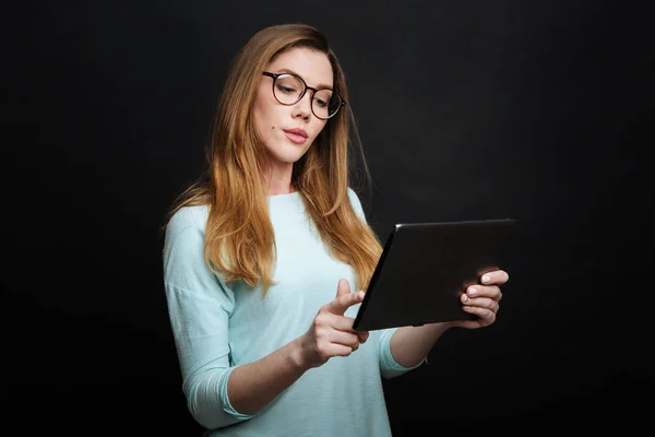 Mulher jovem inteligente usando tablet moderno no estúdio — Fotografia de Stock
