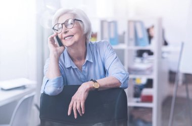 Relaxed mature woman having telephone call clipart