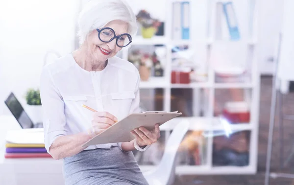 Portrait de femme positive tout en prenant des notes — Photo