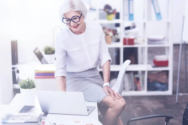 Donna positiva guardando il suo computer portatile — Foto Stock