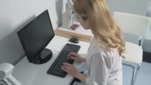 Доктор використовує комп'ютер у своєму офісі — стокове відео