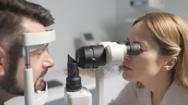 Kadın optometrist hasta için görüş testi yapıyor.
