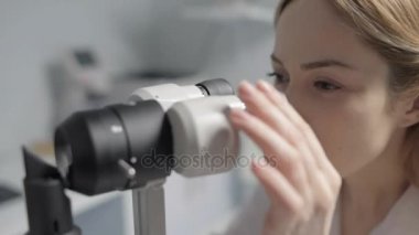 Kadın profesyonel docotr gözleri inceleyerek üzerinde görünümü kadar ölçekli