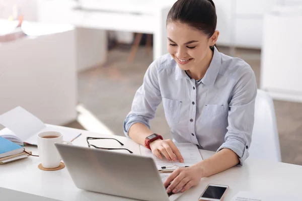 Attraktivt leende kvinna sitter i office — Stockfoto