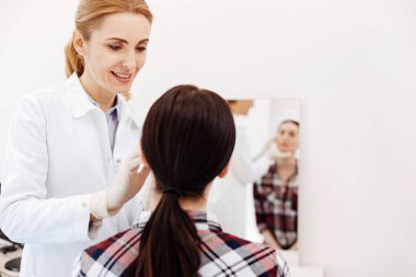 Hastaların yüzüne bakarak memnun dost doktor