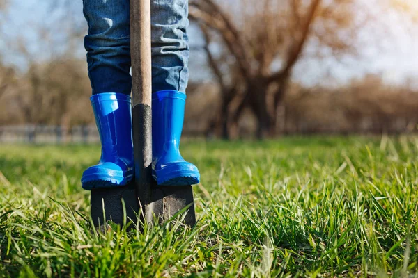 Close up of childs feet in rubber boots on shovel — Stock Photo, Image