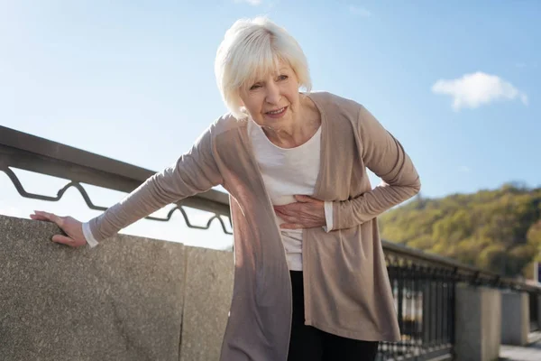 Gepensioneerde vrouw gevoel pijn tijdens de promenade — Stockfoto