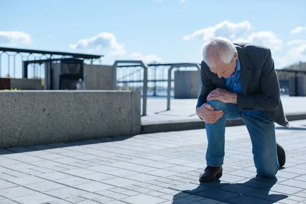 Besorgter Senior mit Knieproblemen im Freien — Stockfoto