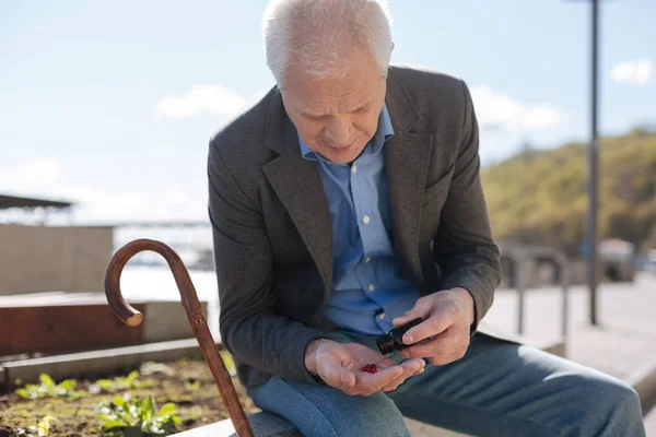 Pensionista sonriente contando sus tabletas en el camino — Foto de Stock