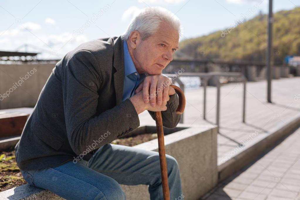 Lonely pensioner observing all around outdoors