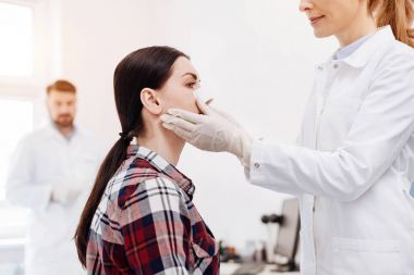 Güzel neşeli doktor hastaları yüz tutan