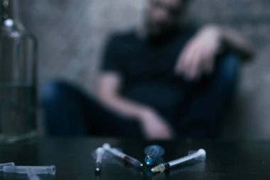 Karanlıkta masanın üzerinde yatan enfekte şırınga