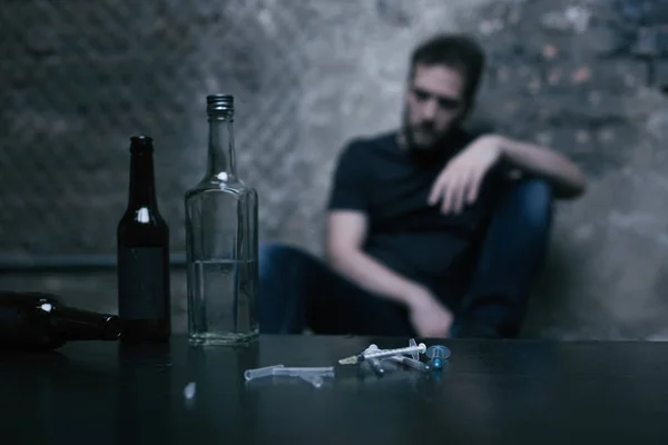 Alkohol, palack, és feküdt az asztalon használt fecskendők — Stock Fotó