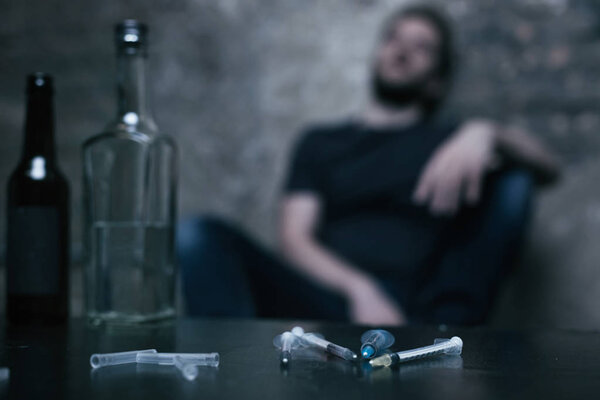 Несколько медицинских шприцов, лежащих в комнате с темным освещением
