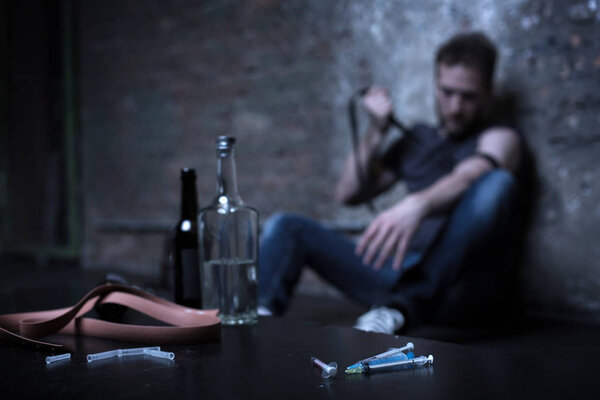 Отчаянный наркоман колол вены в темном подвале

