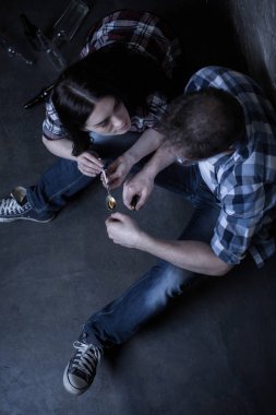 Yorgun keşler kokain alev üzerinde karanlıkta hazırlanıyor.