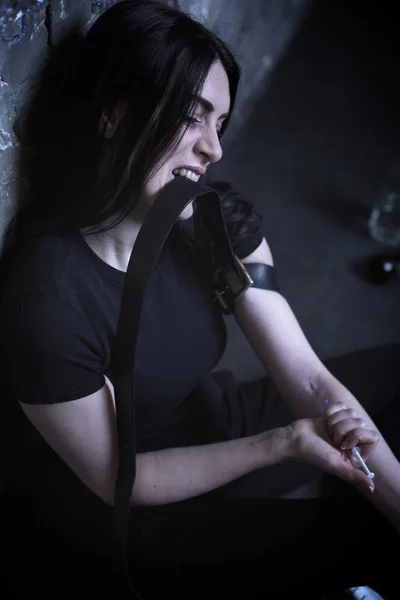 Expressive addicted woman making drug injection in the dark place — Stock Photo, Image
