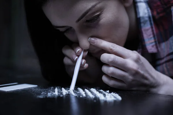 Concentrated junkie snorting heroin lines in the dark place — Stock Photo, Image