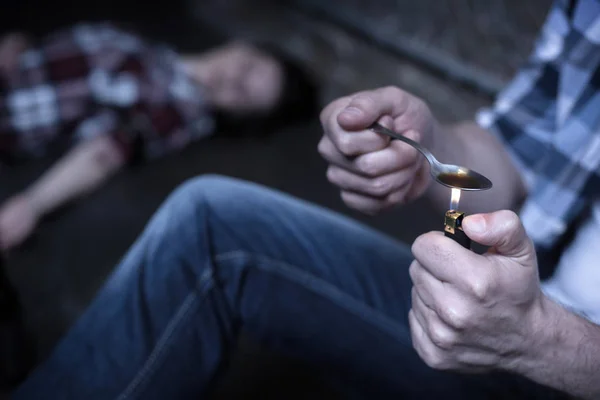 Heroin addicted madman heating new dose on the street — Stock Photo, Image