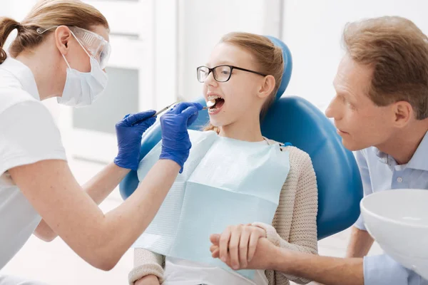 Dentista atencioso concentrado certificando-se de que os dentes dos pacientes são saudáveis — Fotografia de Stock