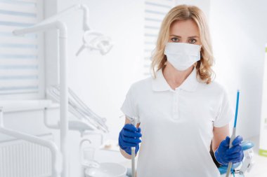 Onun araçları hazır olan yetenekli ayrıntılı diş hekimi