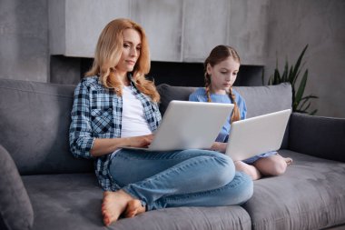 Olgun anne ve küçük kızı kapalı Internet'te sörf konsantre