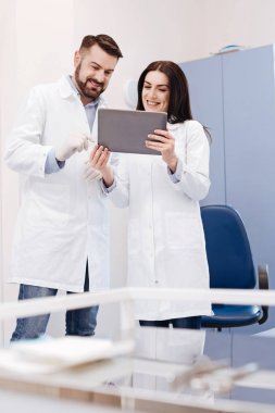 Tablet ekranına bakarak çok mutlu neşeli doktorlar