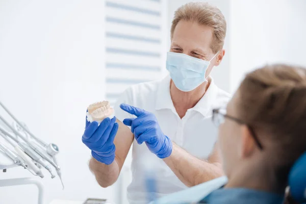 Abile dentista esperto dando al suo paziente una lezione — Foto Stock