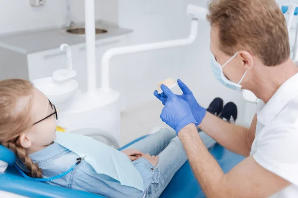 Cool dentista habilidoso dando uma palestra sobre higiene dental — Fotografia de Stock