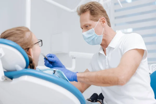 Dedicado dentista local centrado en su tarea — Foto de Stock