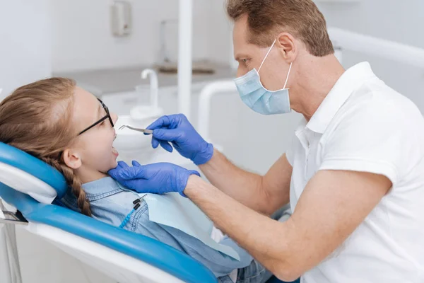Entrenado dentista profesional siendo muy cuidadoso — Foto de Stock