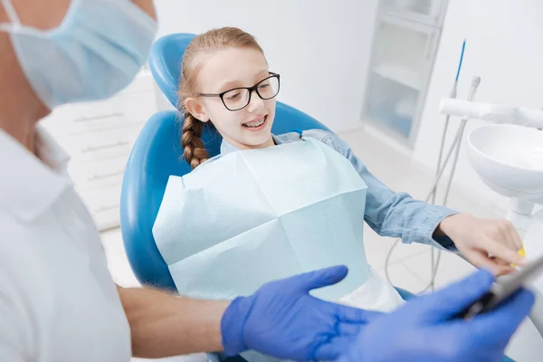 Dentista que utiliza gadget con fines educativos — Foto de Stock