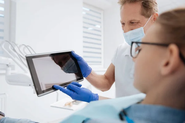 Dentysta przy użyciu gadżet dla wyjaśnienia — Zdjęcie stockowe