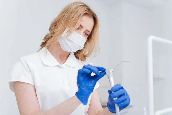 Vidunderlig pæn tandlæge rengøring hendes udstyr - Stock-foto