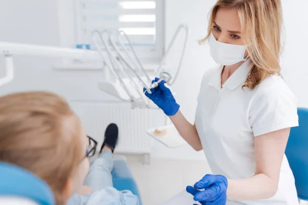 Distinto jovem dentista fazendo seu trabalho graciosamente — Fotografia de Stock