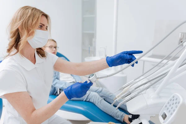 Capace dentista professionista raccogliendo lo strumento — Foto Stock