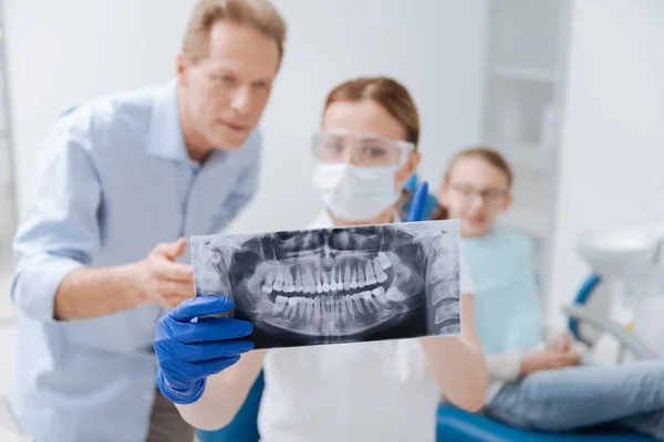Dentista determinado indicando problemas — Fotografia de Stock