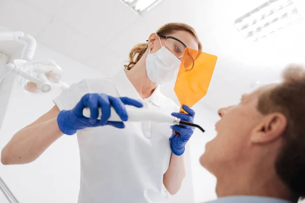 Dentysta, patrząc przez specjalny obiektyw — Zdjęcie stockowe