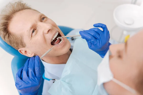 Dentista observando cada rincón de la cavidad — Foto de Stock