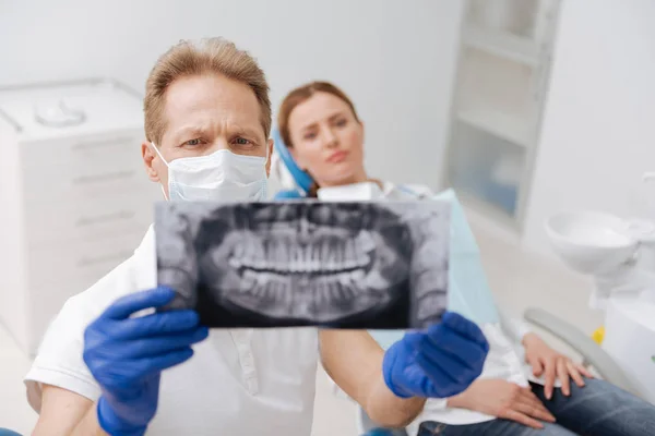 Dentista estudando a varredura da mandíbula do paciente — Fotografia de Stock