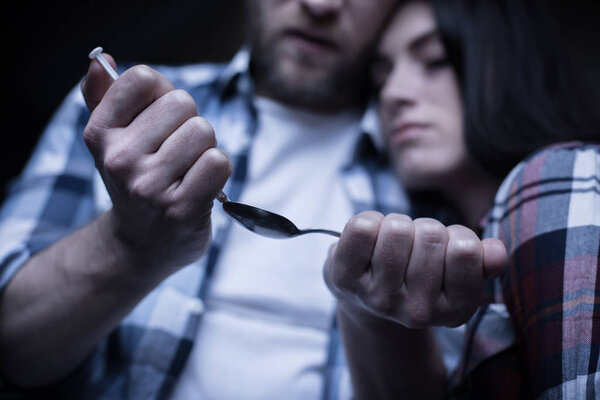Apathetic addicted couple preparing drug dose 
