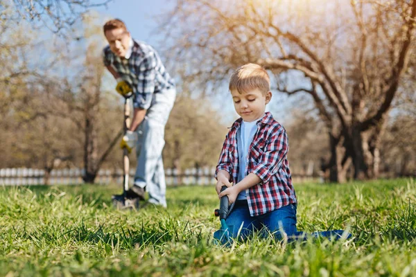 Niño ayudando a su padre en el jardín — Foto de Stock