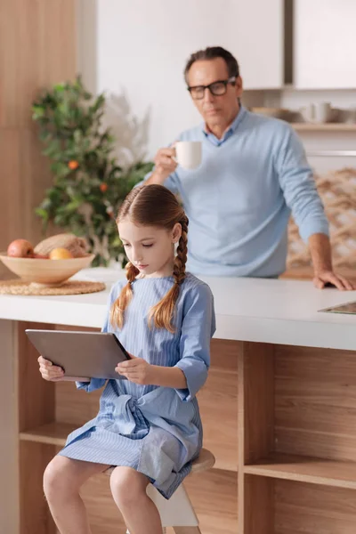 Encantadora niña usando un dispositivo digital y jugando juegos en el interior — Foto de Stock