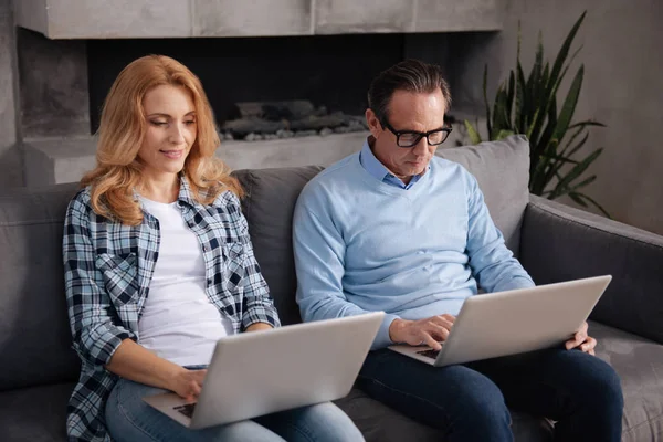 Süchtige reife Frau und gealterter Vater benutzen Laptops in Innenräumen — Stockfoto